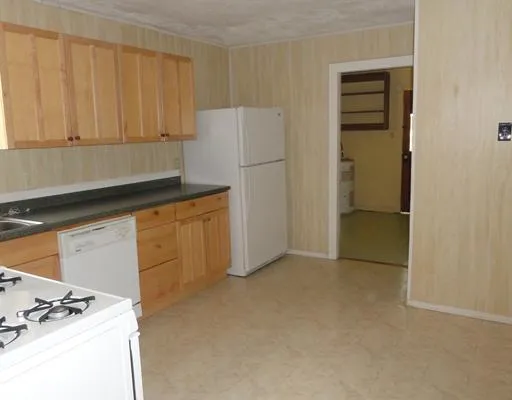 a kitchen with granite countertop cabinets and refrigerator