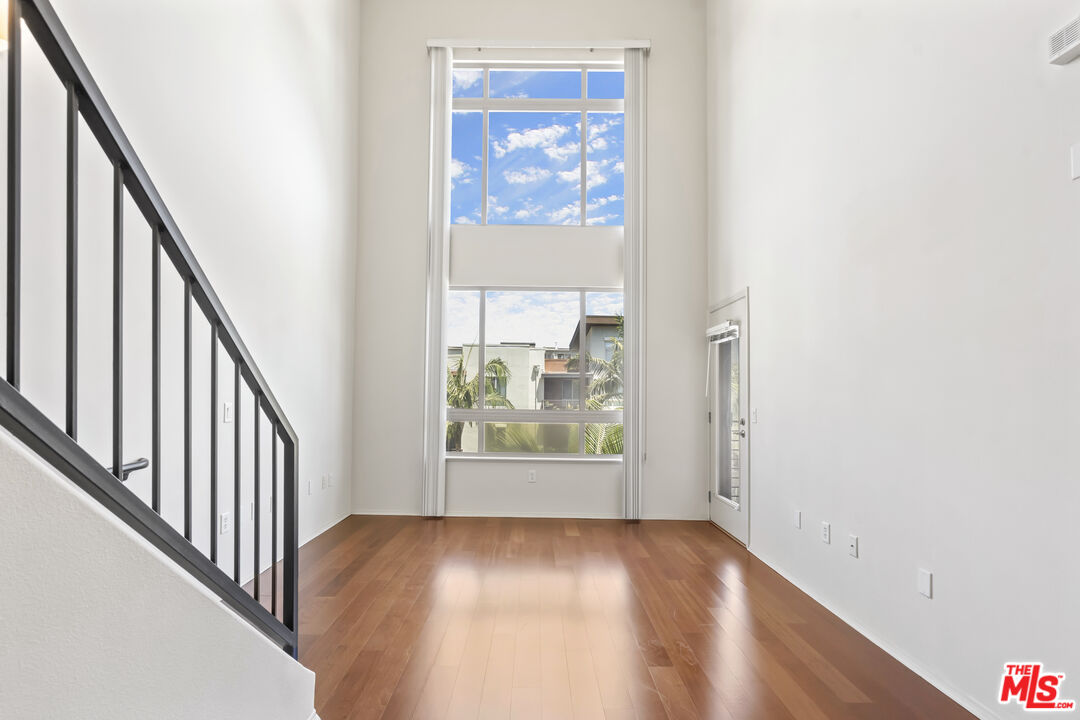 100 South Alameda Street, Unit 418 Los Angeles, CA 90012 - Photo 11 of 32 a view of an empty room with wooden floor and windows