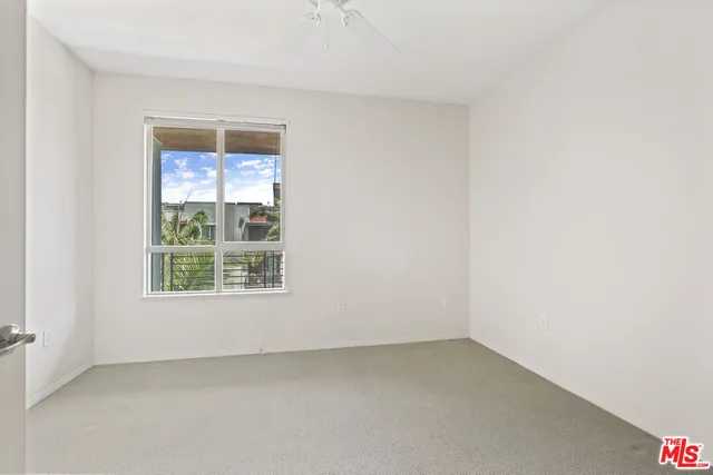 an empty room with a ceiling fan and a bathroom