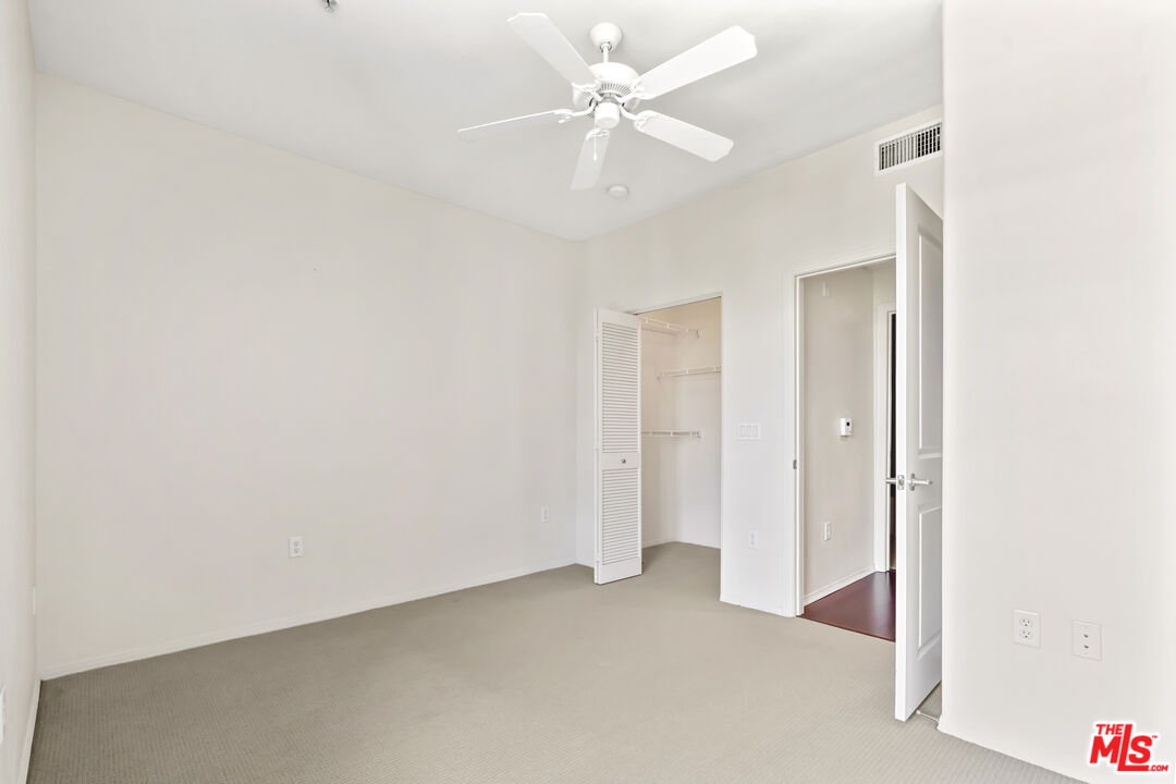 100 South Alameda Street, Unit 418 Los Angeles, CA 90012 - Photo 14 of 32 an empty room with a ceiling fan and a bathroom