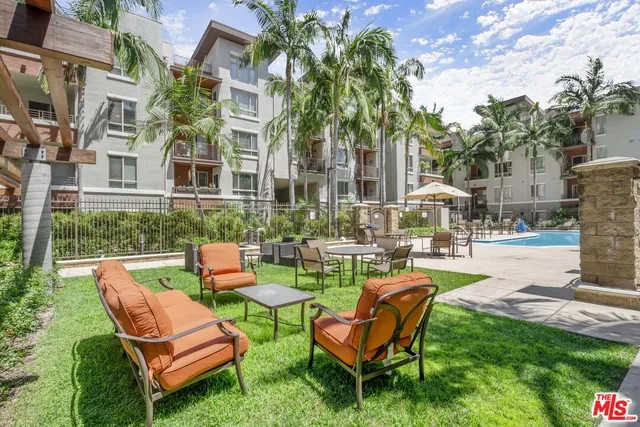 a large living room with stainless steel appliances kitchen island granite countertop a couch and cabinets