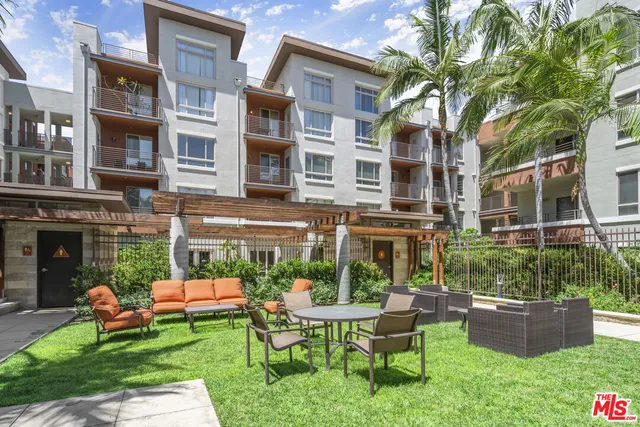 a living room with furniture kitchen view and a wooden floor