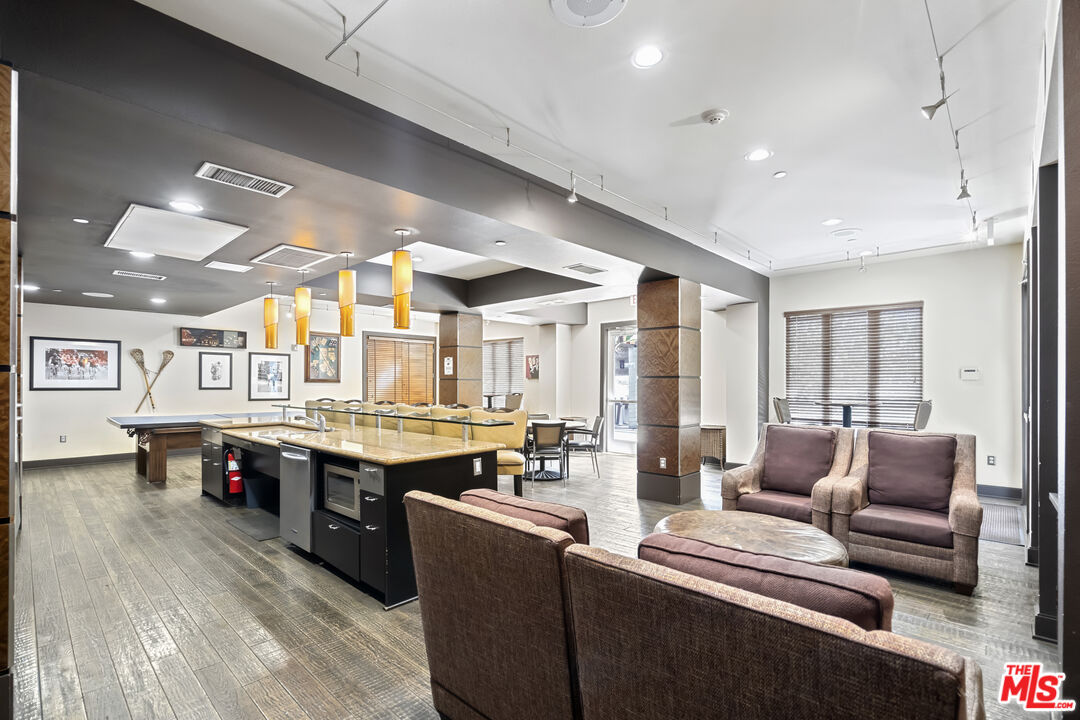 100 South Alameda Street, Unit 418 Los Angeles, CA 90012 - Photo 27 of 32 a large living room with stainless steel appliances kitchen island granite countertop a couch and cabinets