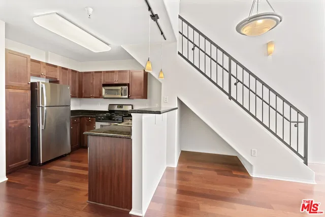 a kitchen with stainless steel appliances granite countertop a refrigerator and a stove top oven