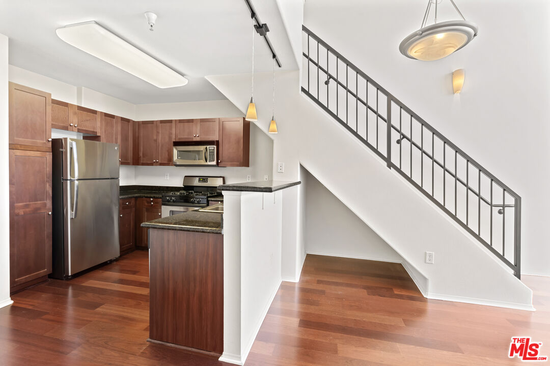 100 South Alameda Street, Unit 418 Los Angeles, CA 90012 - Photo 6 of 32 a kitchen with stainless steel appliances granite countertop a refrigerator and a stove top oven