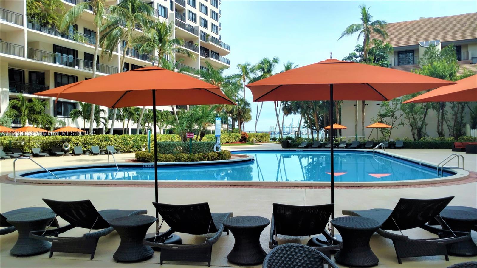 a view of swimming pool with chairs and an umbrella