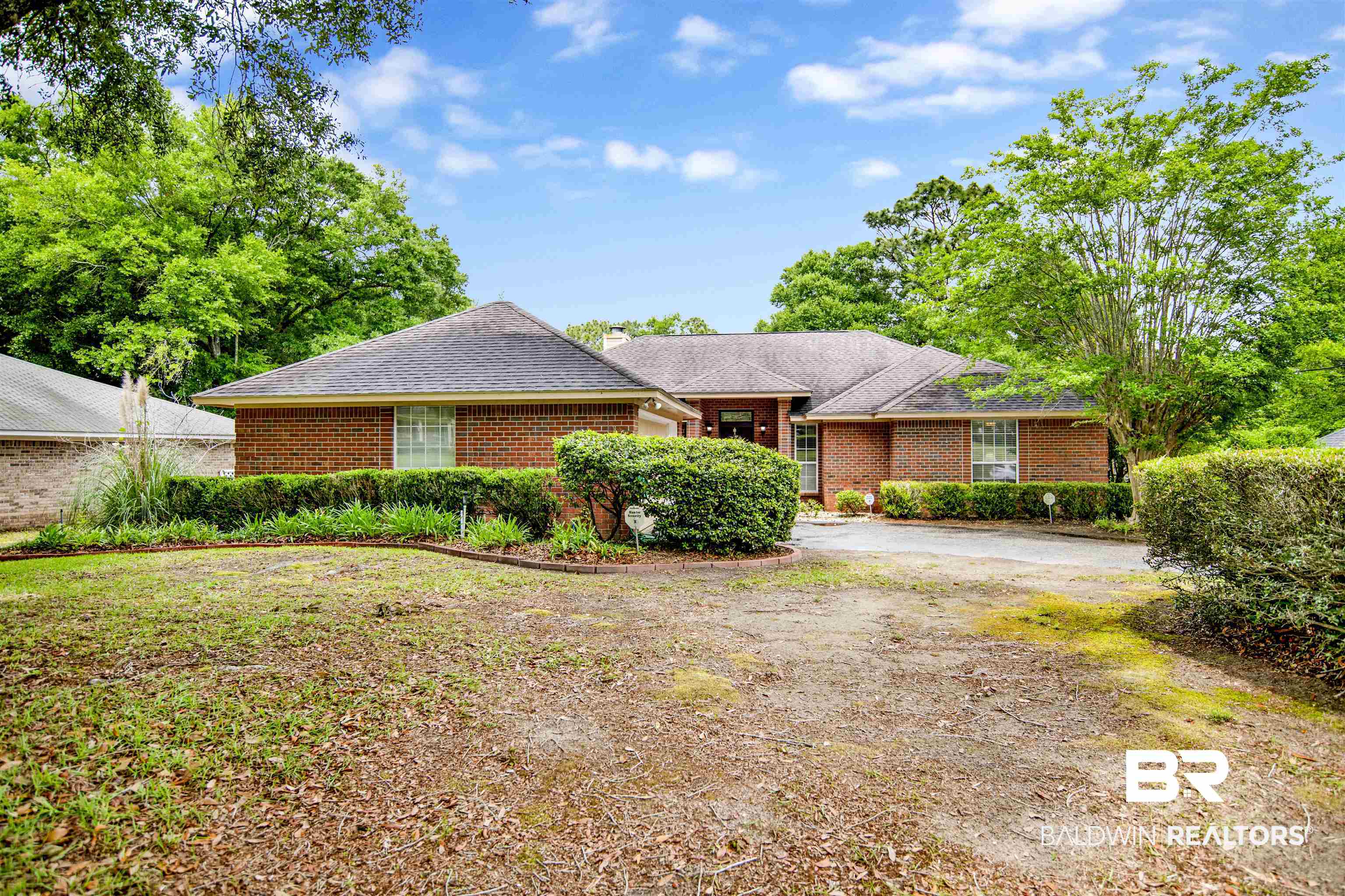 107 Virginia Circle Daphne, AL 36526 - Photo 2 of 47 Brick exterior residence featuring a dark shingle roof and surrounding mature trees