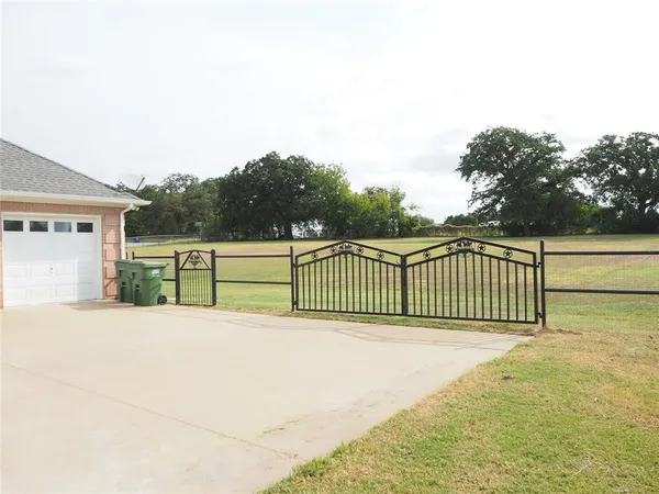 a view of a fence and trees in the background