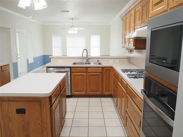a kitchen with a sink a stove top oven and cabinetry