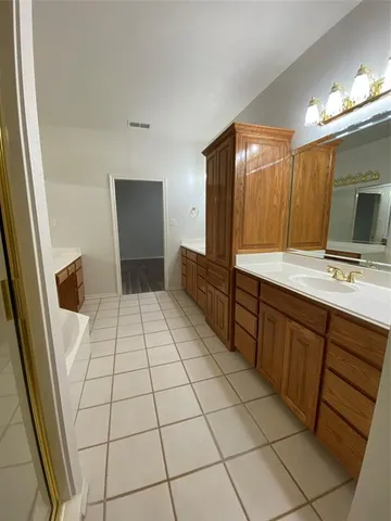 a spacious bathroom with a mirror and a sink