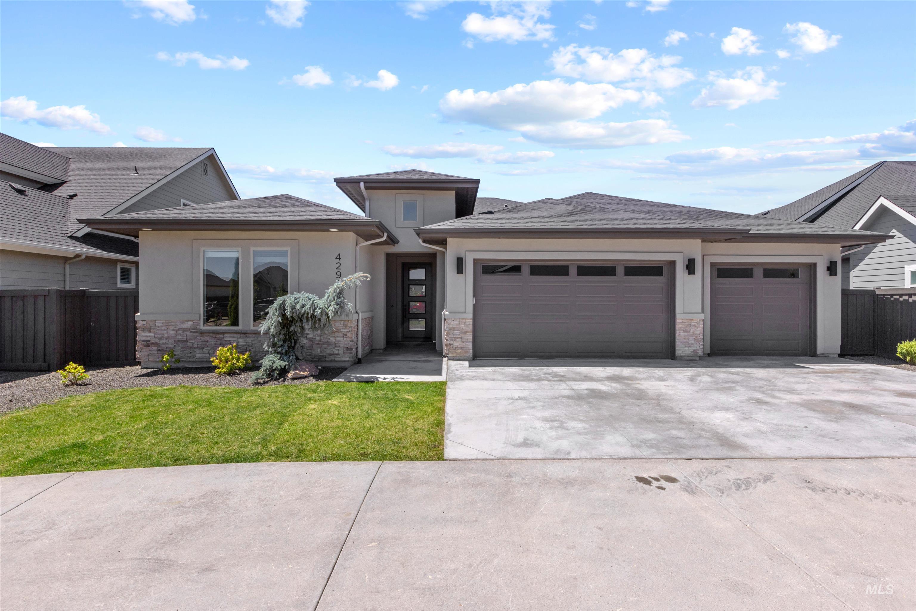 4291 North Brody Way Meridian, ID 83646 - Photo 1 of 1 Prairie-style house featuring an attached garage, driveway, stone siding, stucco siding, and a shingled roof