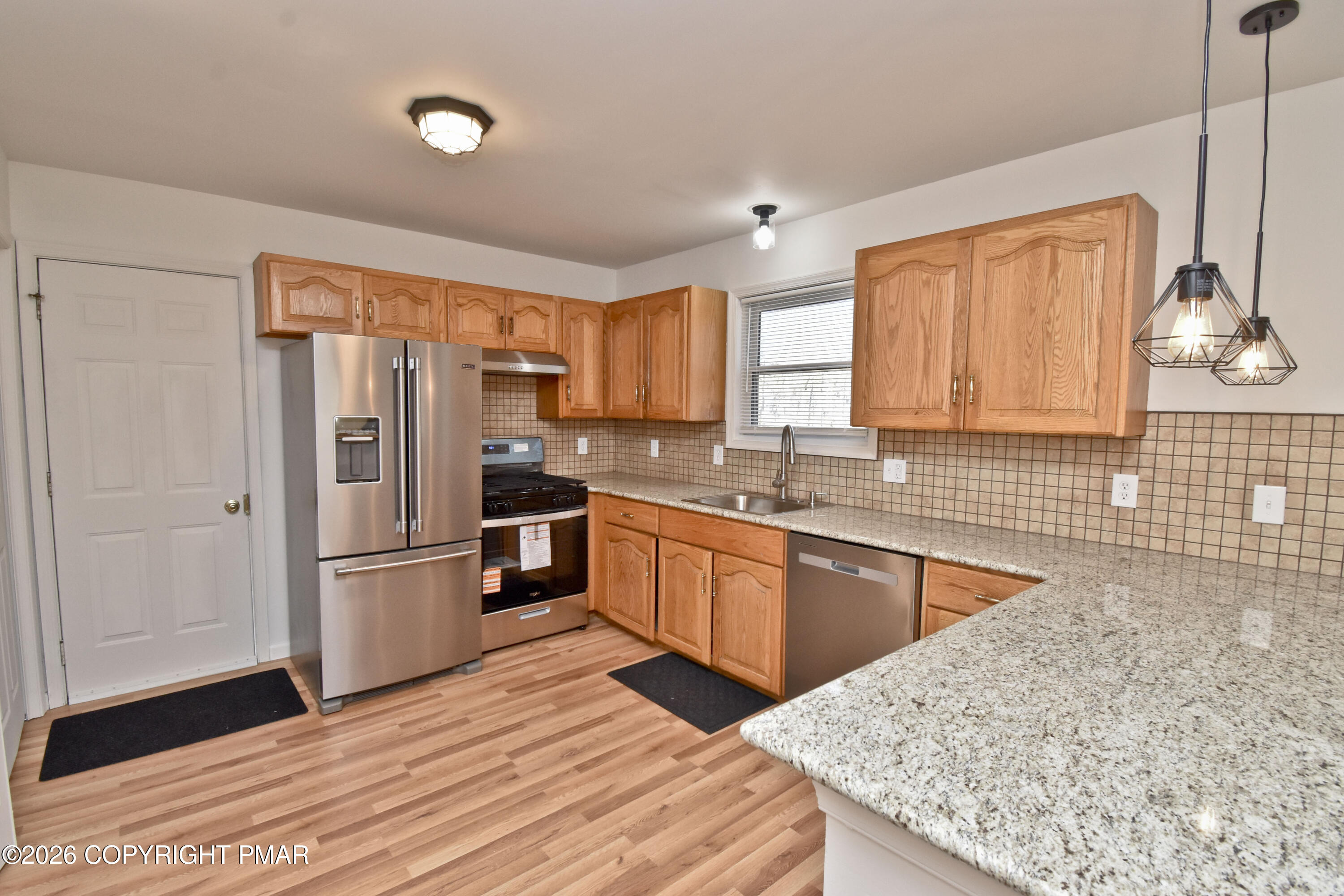 108 Pipher Road Bushkill, PA 18324 - Photo 14 of 50 a kitchen with stainless steel appliances granite countertop a refrigerator a sink dishwasher a stove with wooden cabinets and floor