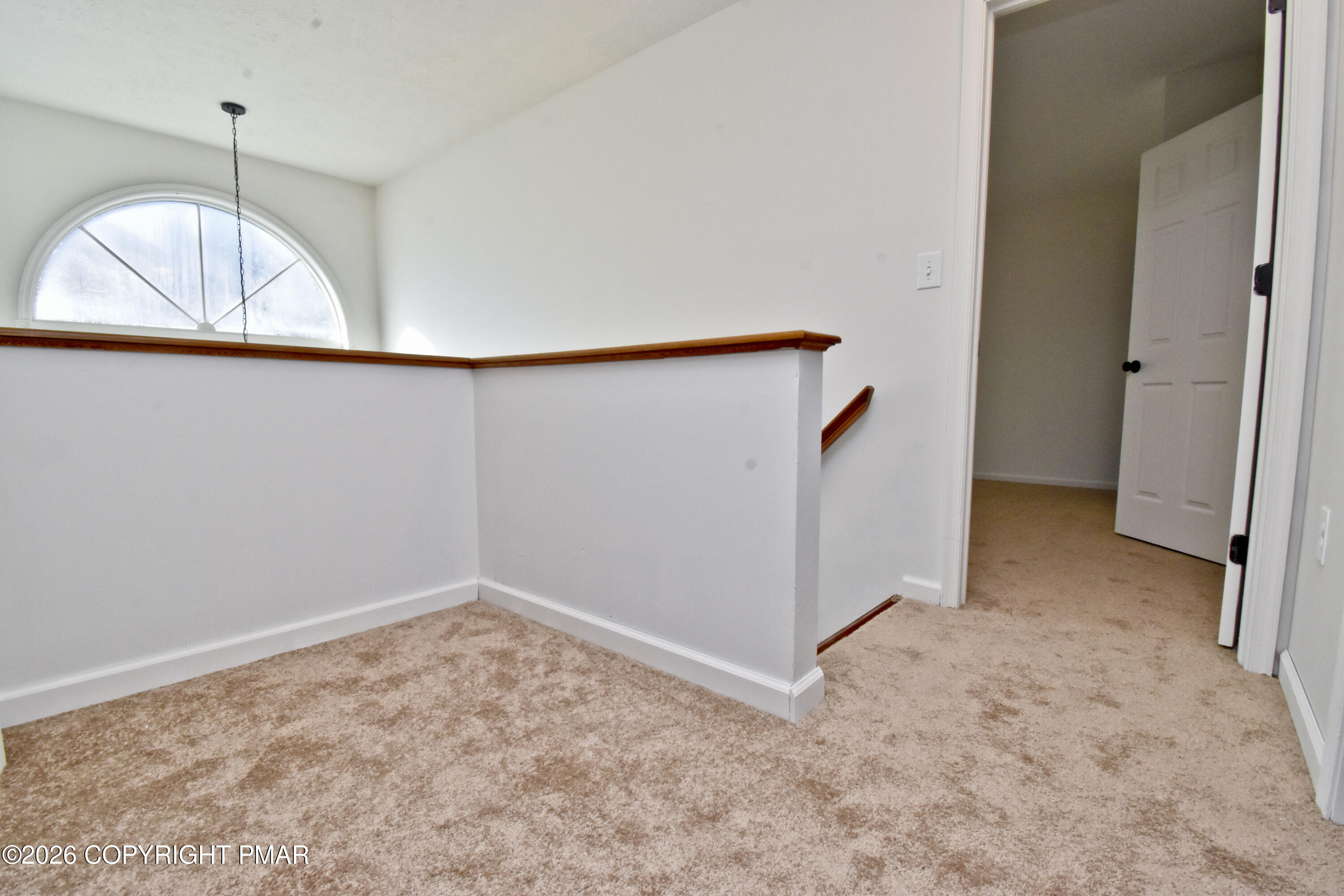 108 Pipher Road Bushkill, PA 18324 - Photo 23 of 50 an empty room with a chandelier fan and kitchen view