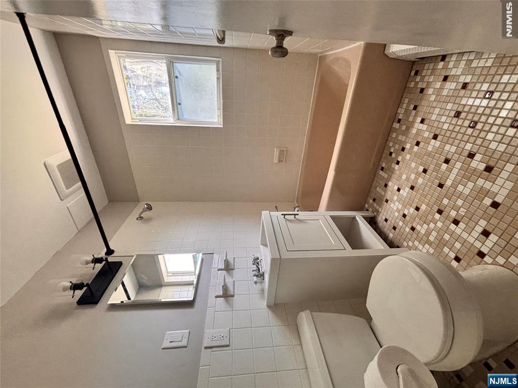 21 Wanamaker Avenue, Unit 1 Waldwick, NJ 07463 - Photo 10 of 13 a bathroom with a sink a toilet and shower