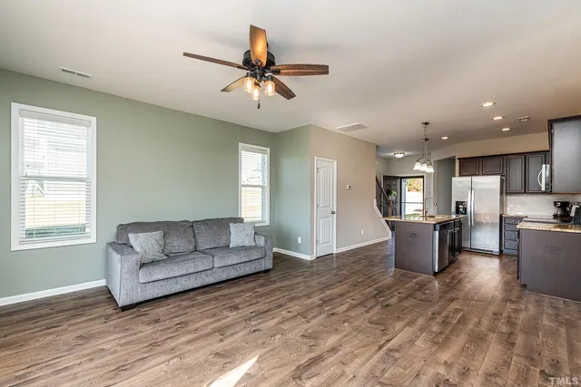 a living room with furniture and a wooden floor