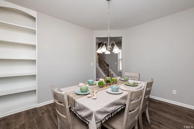 a view of a dining room with furniture a chandelier and wooden floor