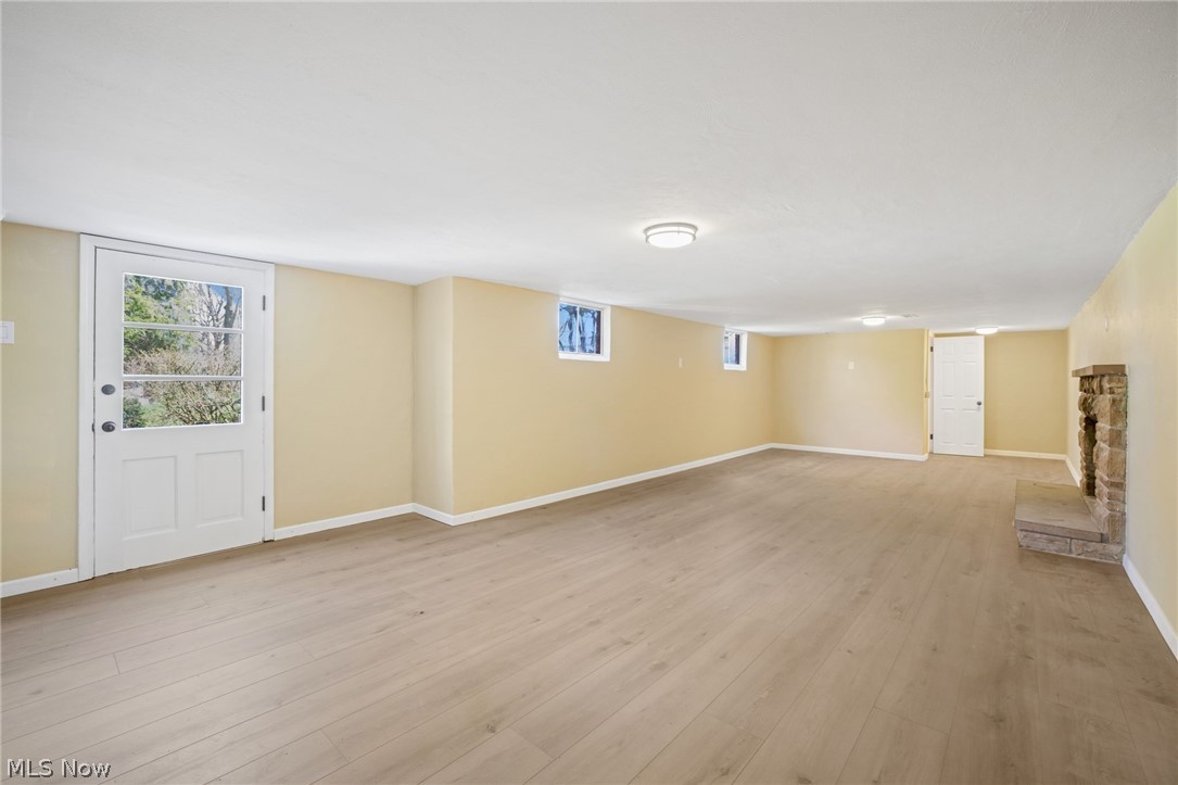 154 Winchester Road Akron, OH 44333 - Photo 22 of 26 Basement featuring a brick fireplace and light wood-type flooring