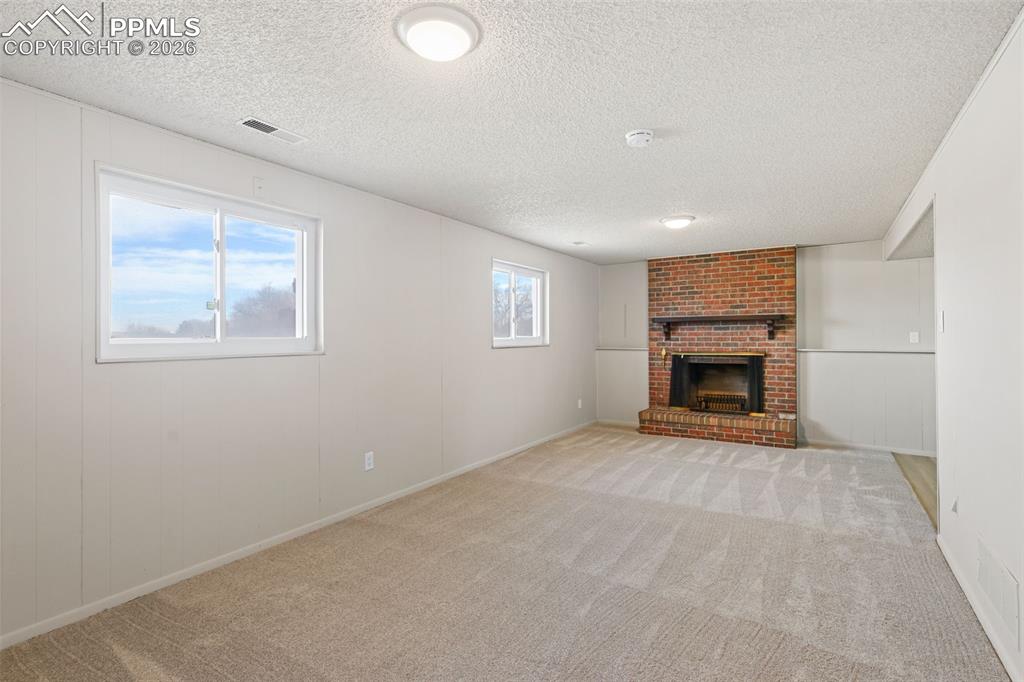 1620 Winnebago Road Colorado Springs, CO 80915 - Photo 16 of 25 an empty room with fireplace and windows