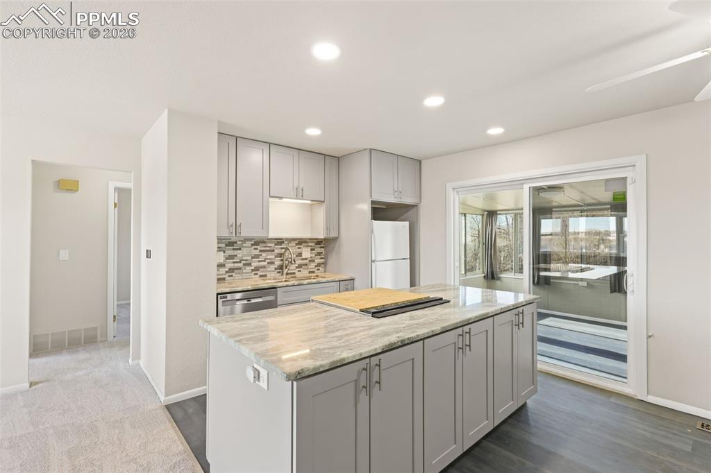 1620 Winnebago Road Colorado Springs, CO 80915 - Photo 4 of 25 a kitchen with granite countertop a sink and a refrigerator