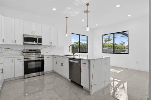 a kitchen with stainless steel appliances kitchen island granite countertop a stove a sink and a microwave