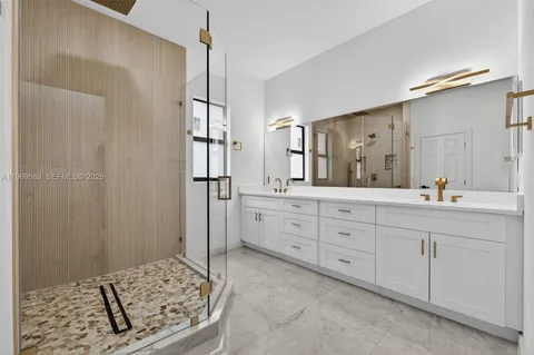 a spacious bathroom with double vanity sink and a shower