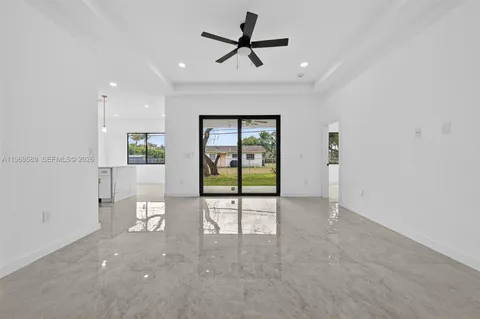 an empty room with windows and ceiling fan