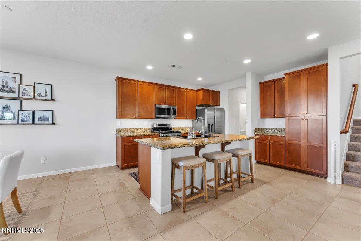 2642 Alessandro Court Sparks, NV 89434 - Photo 14 of 52 a kitchen with stainless steel appliances kitchen island granite countertop a refrigerator and a sink