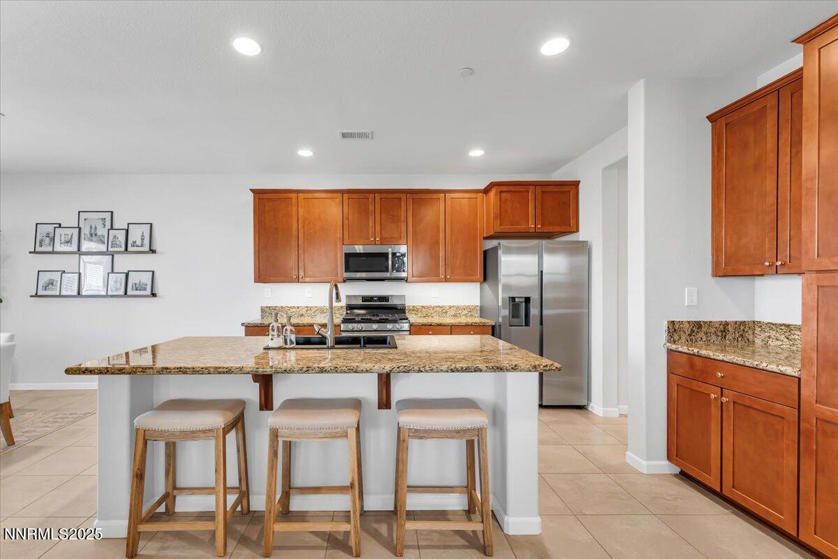 2642 Alessandro Court Sparks, NV 89434 - Photo 15 of 52 a kitchen with stainless steel appliances granite countertop a stove a sink a refrigerator and chairs