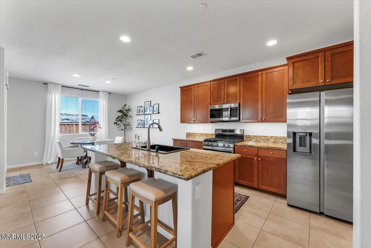 2642 Alessandro Court Sparks, NV 89434 - Photo 16 of 52 a kitchen with stainless steel appliances granite countertop a refrigerator a stove a sink a dining table and chairs