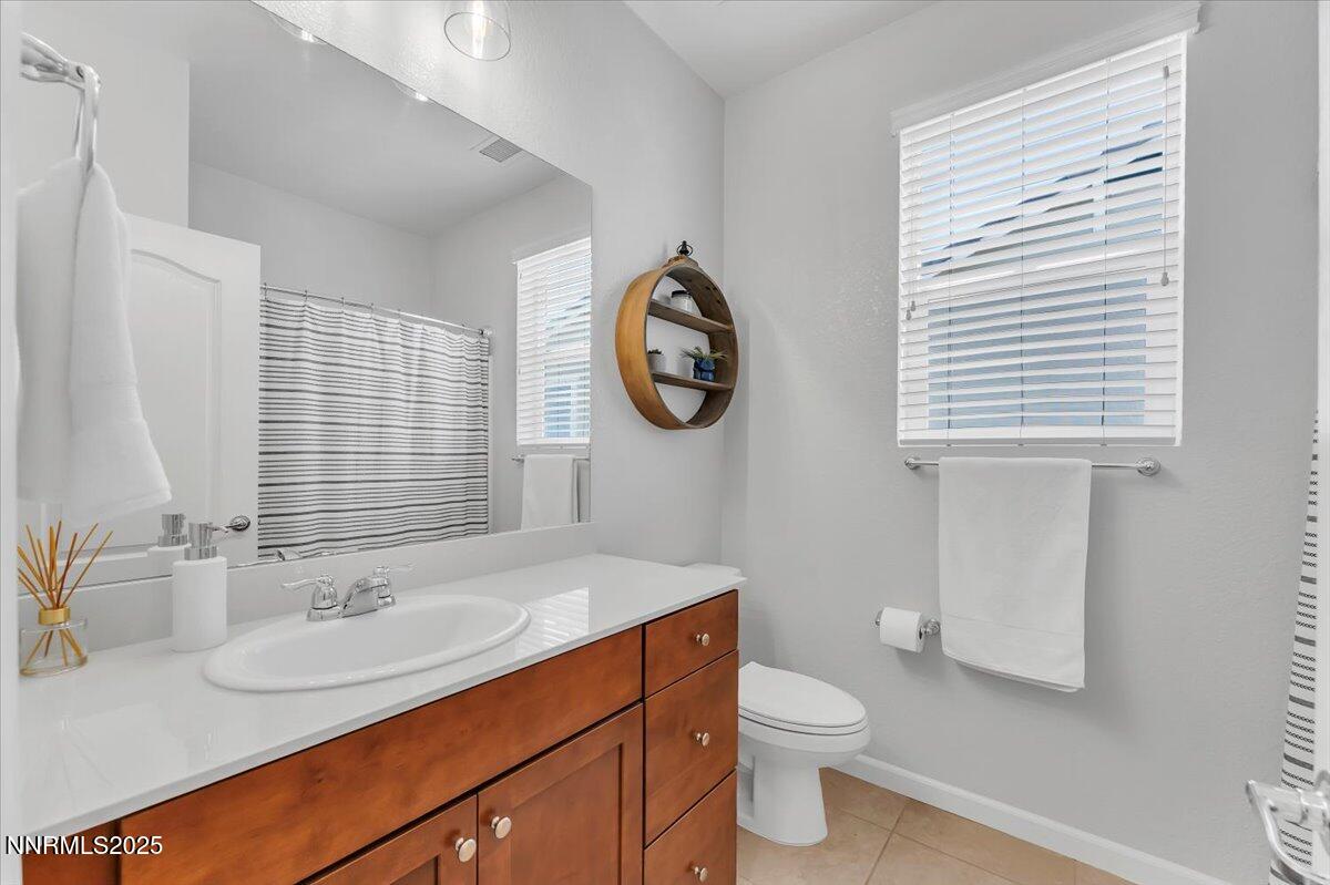 2642 Alessandro Court Sparks, NV 89434 - Photo 25 of 52 a bathroom with a toilet a sink a mirror and a window