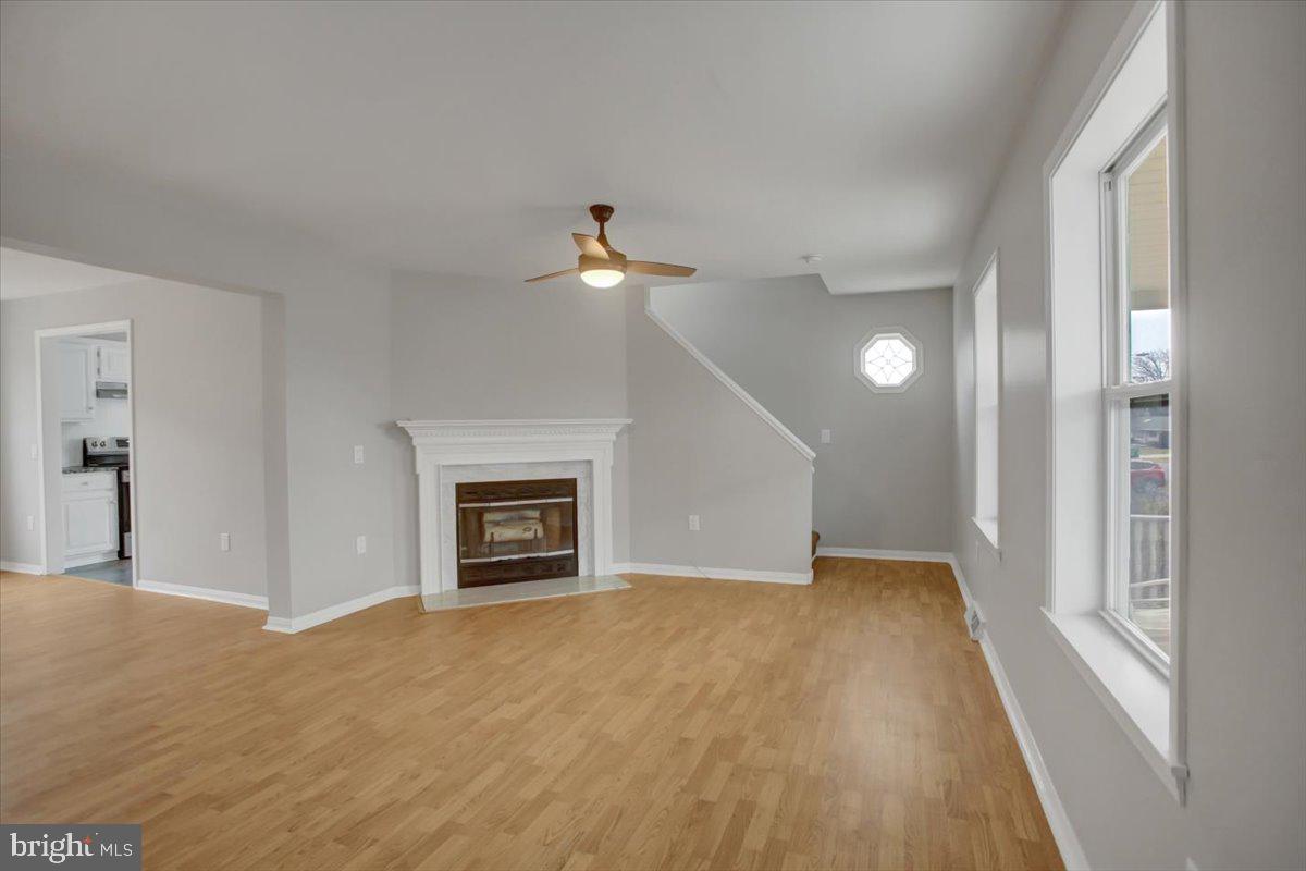 124 West Hunter Road Carlisle, PA 17015 - Photo 5 of 36 an empty room with a fireplace and wooden floor