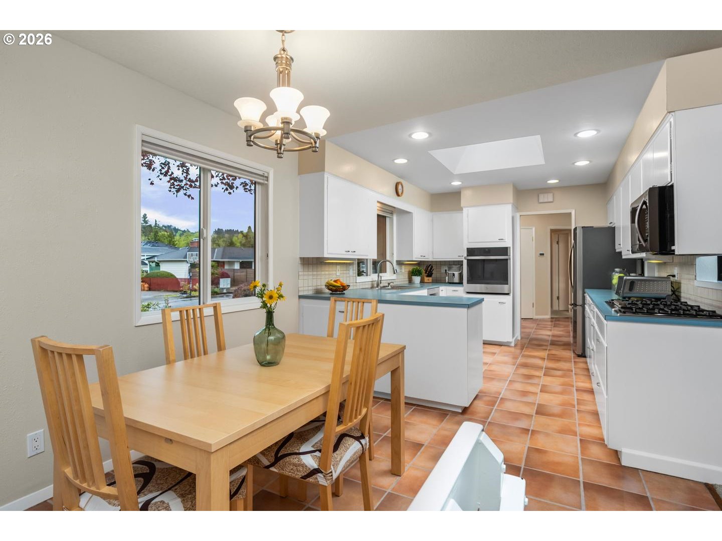 9070 Southwest Howatt Street Portland, OR 97225 - Photo 20 of 48 a kitchen with stainless steel appliances kitchen island granite countertop a table chairs and a refrigerator