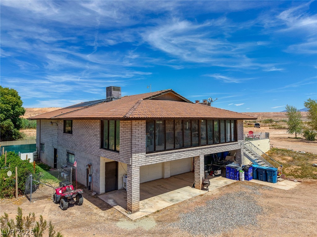 1920 Bowman Road Logandale, NV 89021 - Photo 64 of 68 Substantial brick construction features a tile roof and integrated garage bays under a blue sky.