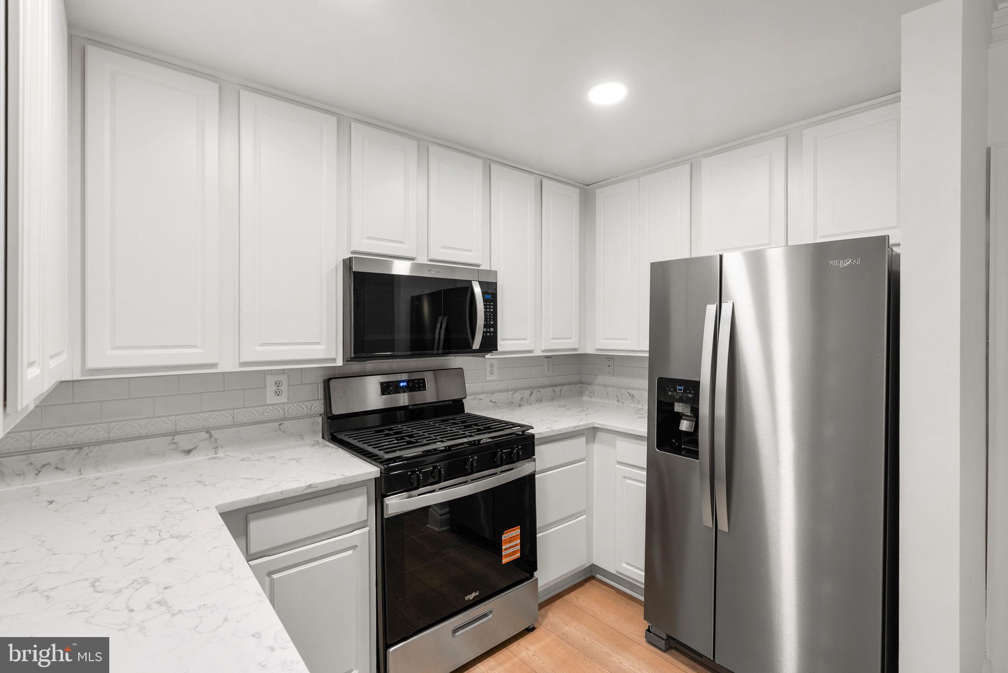 139 Chevy Chase Street, Unit 139 Gaithersburg, MD 20878 - Photo 12 of 27 a kitchen with stainless steel appliances a refrigerator stove and microwave