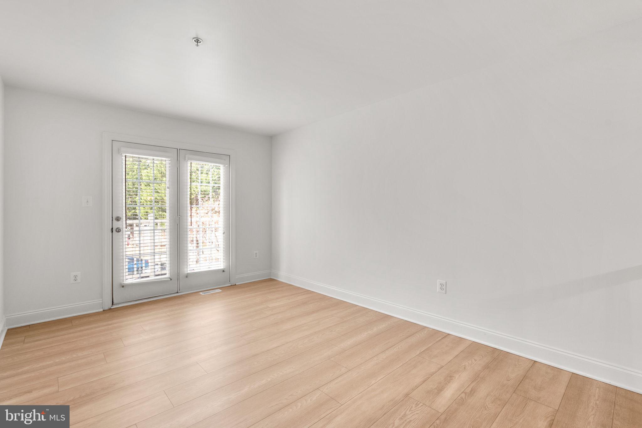 139 Chevy Chase Street, Unit 139 Gaithersburg, MD 20878 - Photo 16 of 27 an empty room with wooden floor and windows