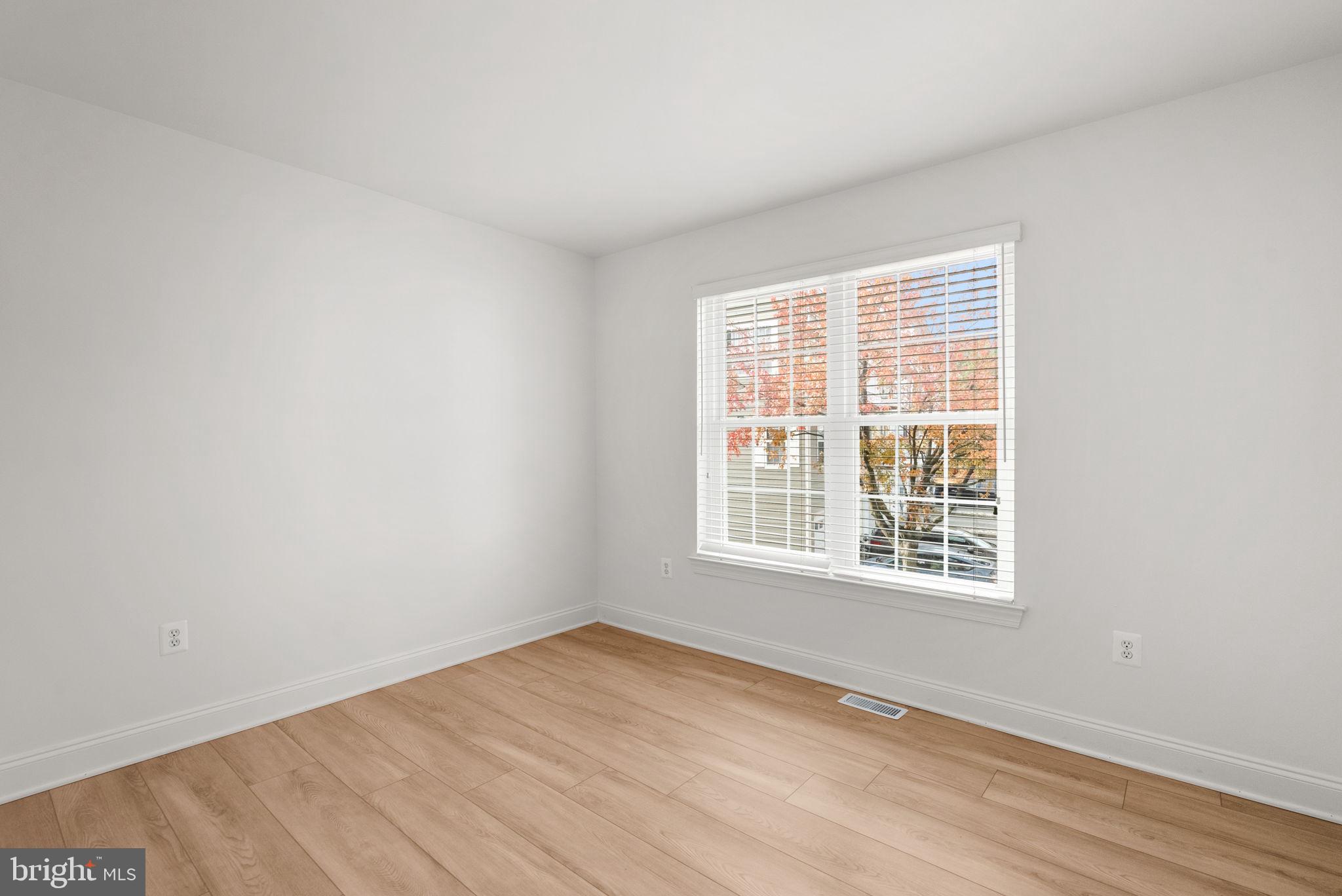 139 Chevy Chase Street, Unit 139 Gaithersburg, MD 20878 - Photo 17 of 27 an empty room with wooden floor and windows