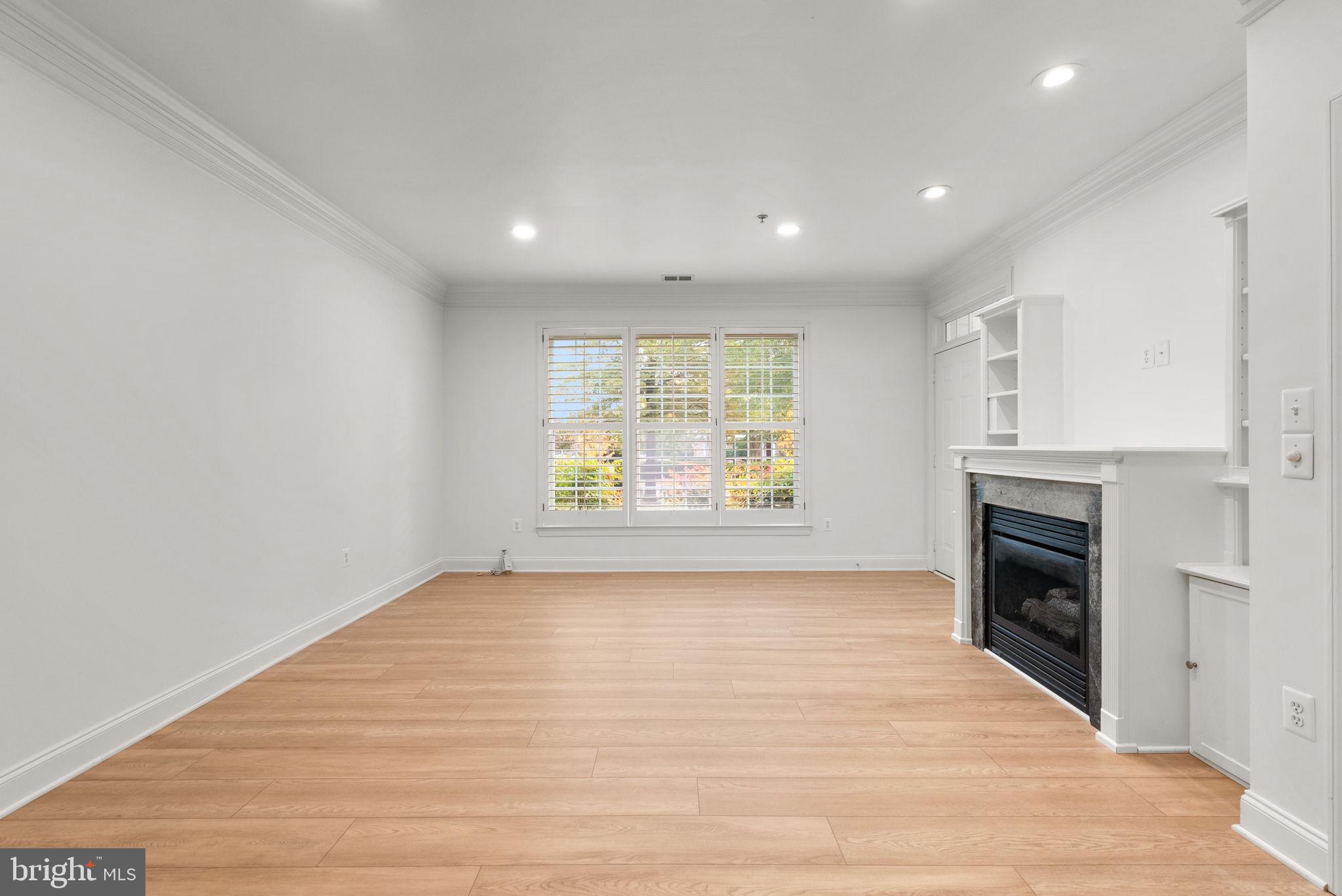 139 Chevy Chase Street, Unit 139 Gaithersburg, MD 20878 - Photo 7 of 27 an empty room with windows and fireplace