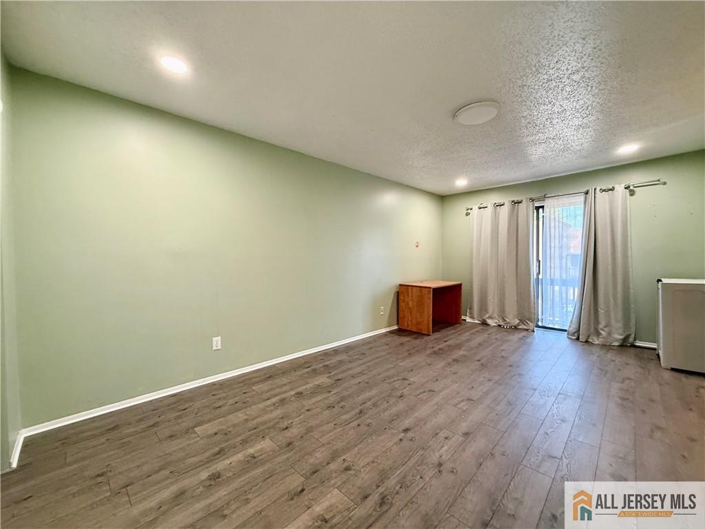 105 Westgate Drive, Unit 105 Edison, NJ 08820 - Photo 18 of 28 an empty room with wooden floor and closet