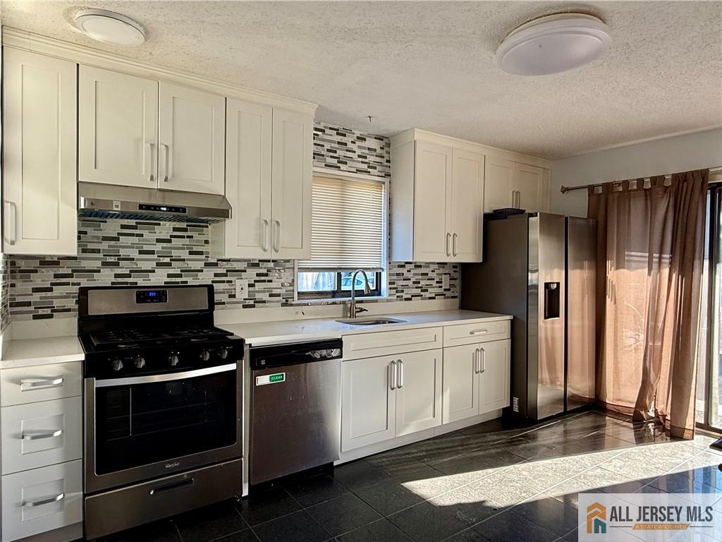 105 Westgate Drive, Unit 105 Edison, NJ 08820 - Photo 8 of 28 a kitchen with stainless steel appliances a stove a refrigerator and cabinets