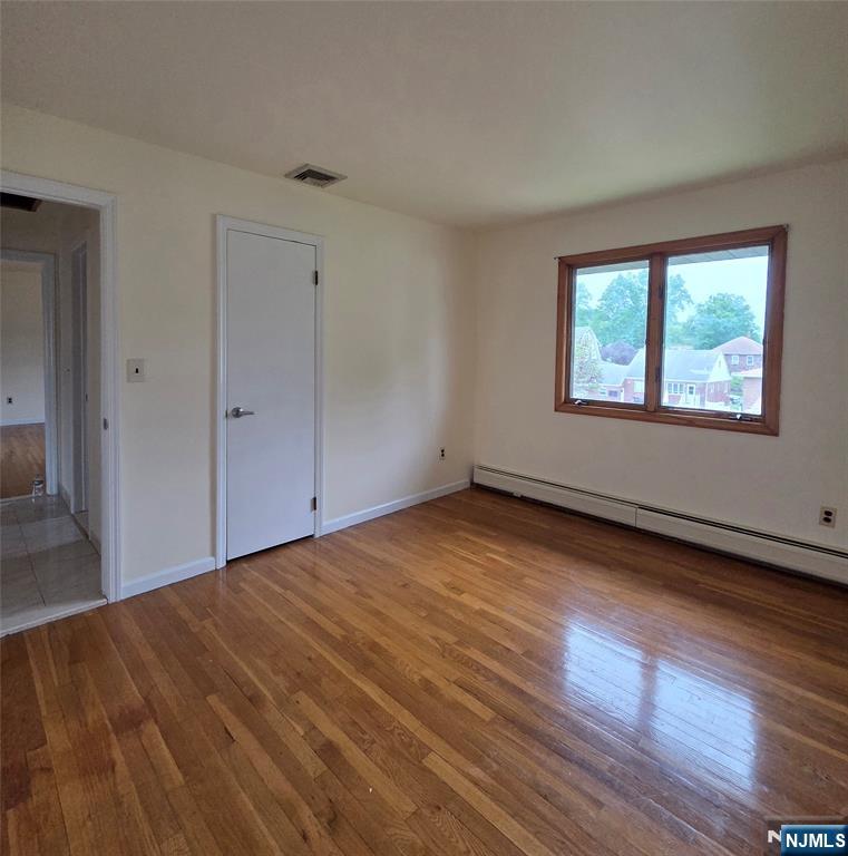 688 Day Avenue, Unit 2 Ridgefield, NJ 07657 - Photo 12 of 18 a view of an empty room with wooden floor and a window