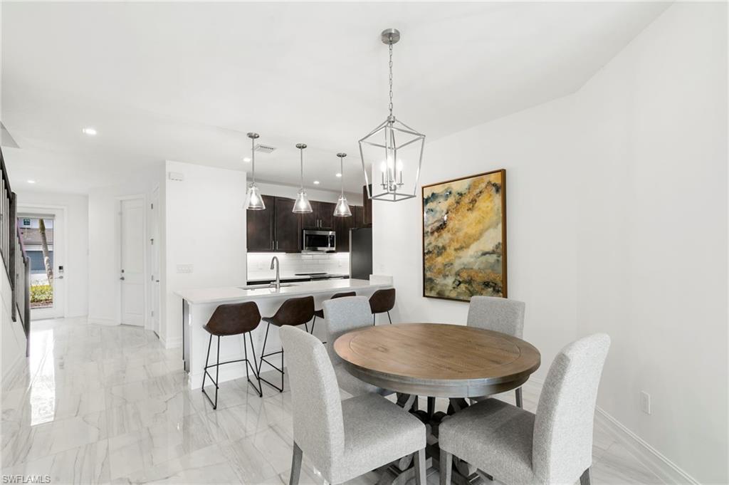 7572 Carnegie Way Naples, FL 34119 - Photo 11 of 43 a view of a dining room with furniture