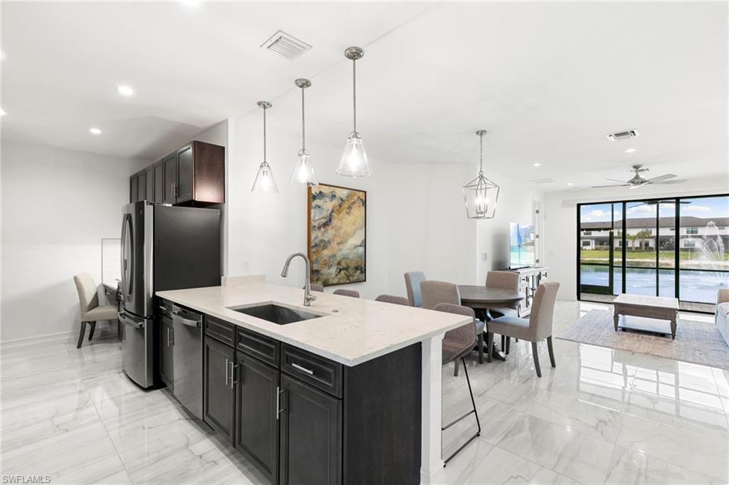 7572 Carnegie Way Naples, FL 34119 - Photo 12 of 43 a kitchen with a sink a counter top space and stainless steel appliances