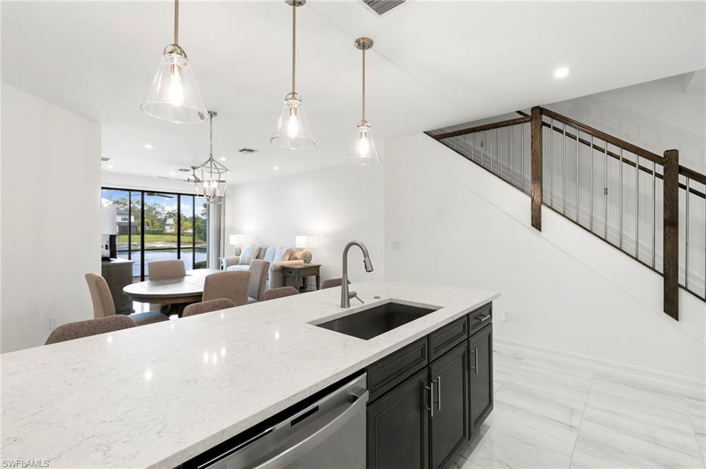 7572 Carnegie Way Naples, FL 34119 - Photo 16 of 43 a kitchen with kitchen island a sink appliances and a counter top space