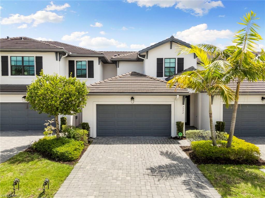 7572 Carnegie Way Naples, FL 34119 - Photo 2 of 43 a front view of a house with garden