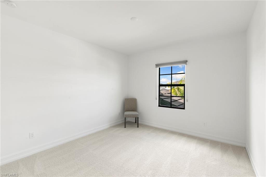 7572 Carnegie Way Naples, FL 34119 - Photo 25 of 43 an empty room with windows and furniture