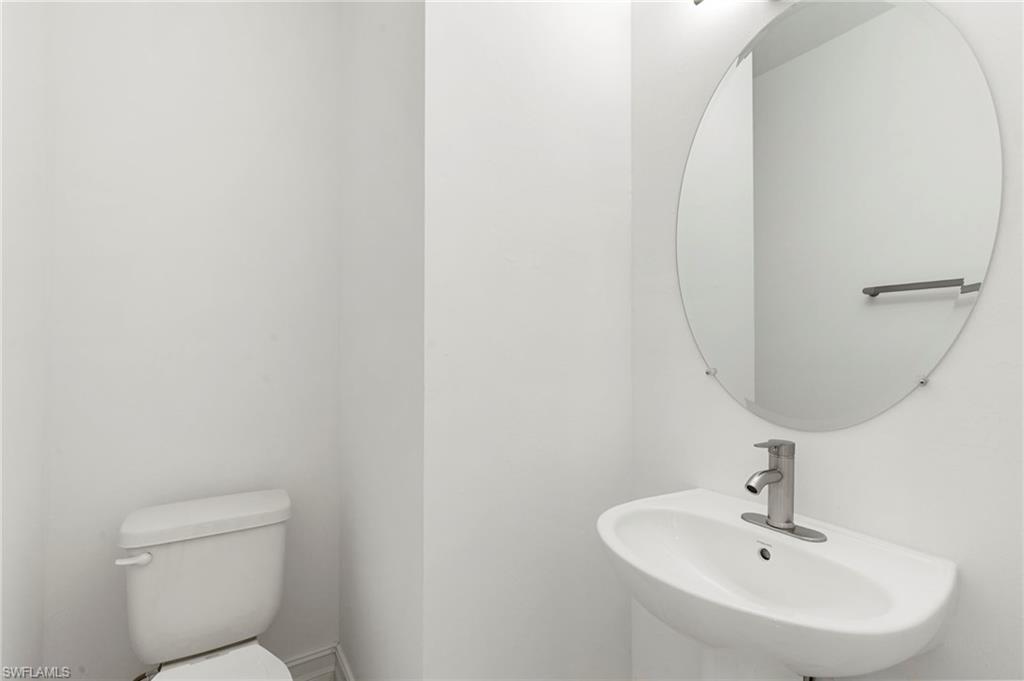 7572 Carnegie Way Naples, FL 34119 - Photo 29 of 43 a bathroom with a sink a toilet and a mirror