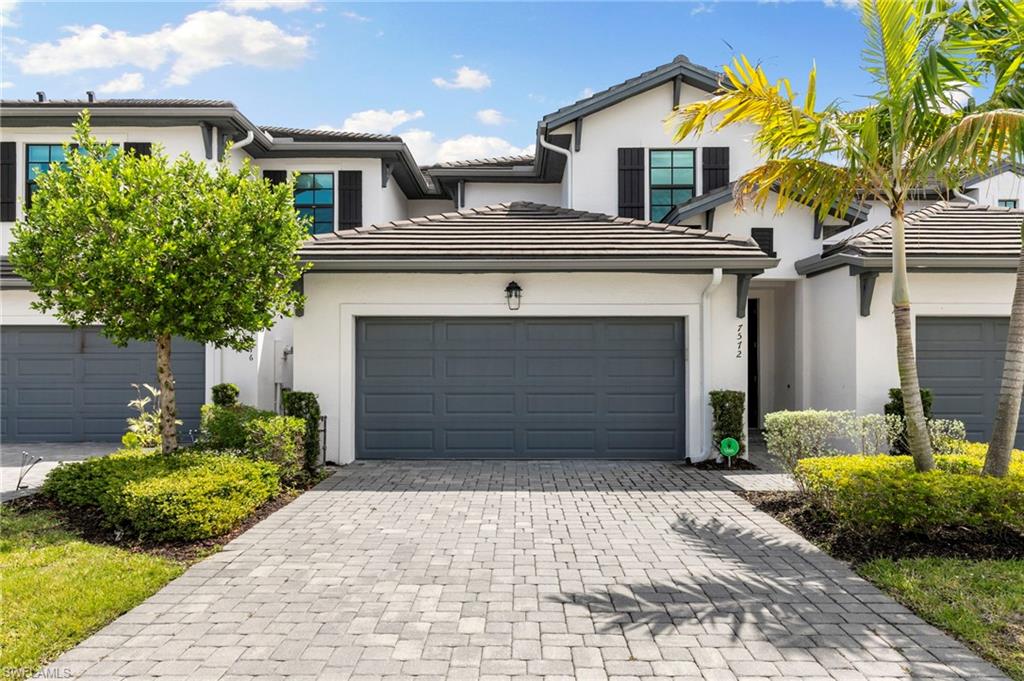 7572 Carnegie Way Naples, FL 34119 - Photo 3 of 43 a front view of a house with a yard and garage