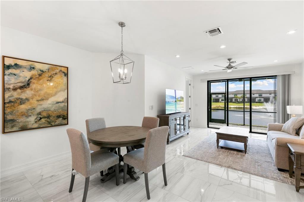 7572 Carnegie Way Naples, FL 34119 - Photo 6 of 43 a living room with furniture a lamp and a large window