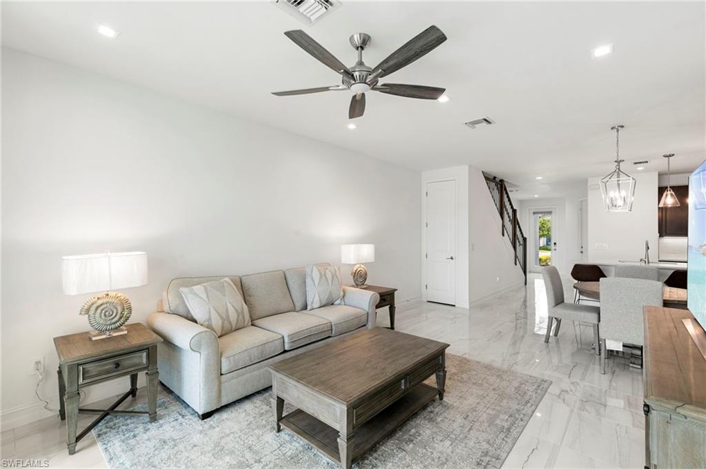 7572 Carnegie Way Naples, FL 34119 - Photo 9 of 43 a living room with furniture a rug and white walls
