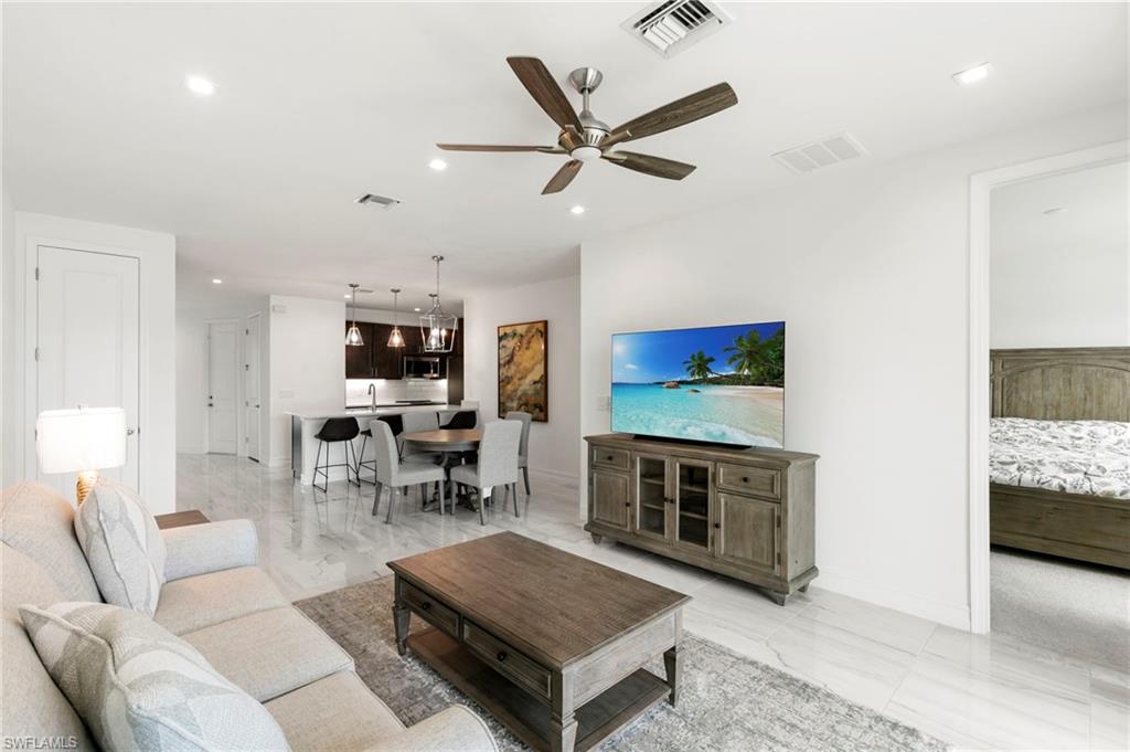 7572 Carnegie Way Naples, FL 34119 - Photo 10 of 43 a living room with furniture a flat screen tv and a fireplace